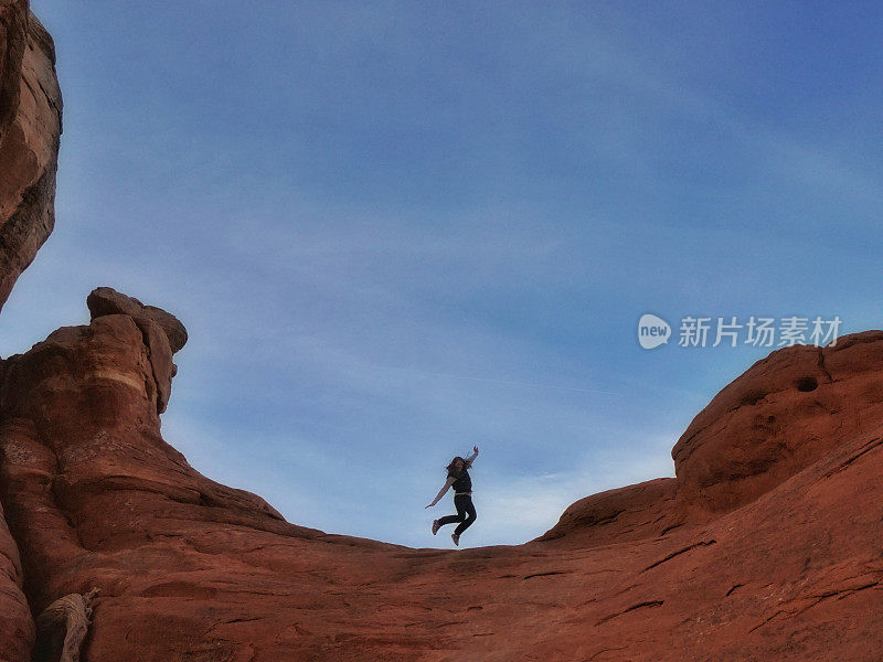 Jumping Mid-air Person Silhouette on Red Rock